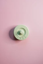 Pastel green fabric weight with 'Bunka' branding on a pink background
